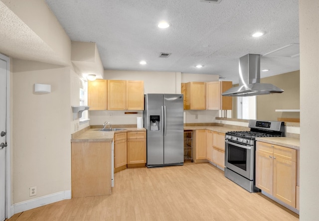 kitchen featuring light brown cabinets, appliances with stainless steel finishes, island range hood, and a textured ceiling