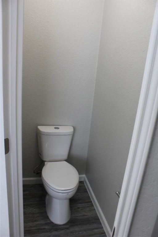 bathroom with toilet and hardwood / wood-style flooring