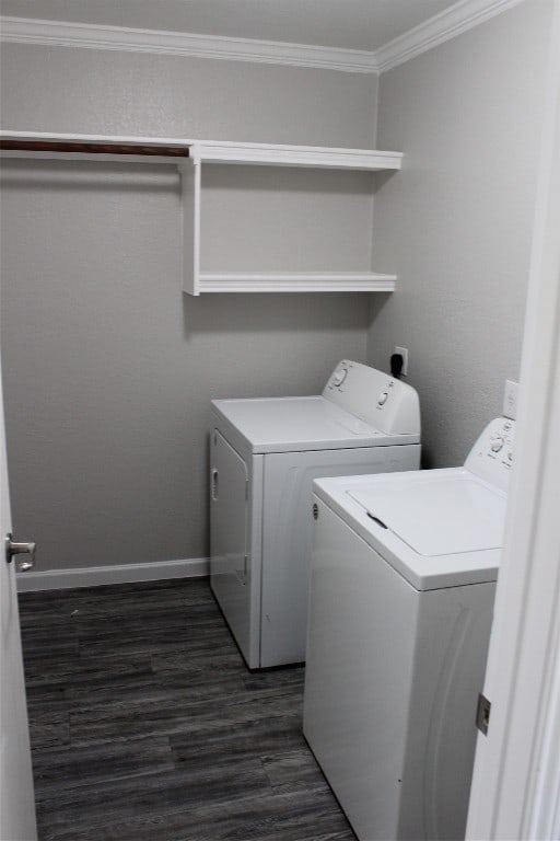 washroom featuring ornamental molding, dark hardwood / wood-style floors, and washer and clothes dryer