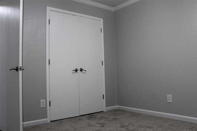 unfurnished bedroom with ornamental molding, light colored carpet, and a closet