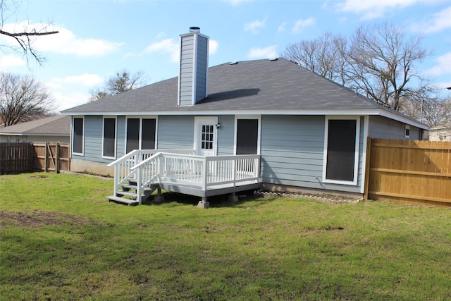 rear view of house with a wooden deck and a yard