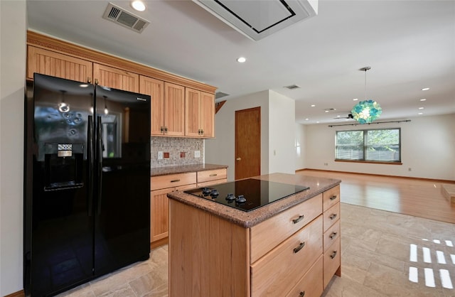 kitchen with decorative backsplash, black appliances, a center island, light wood-type flooring, and light brown cabinetry