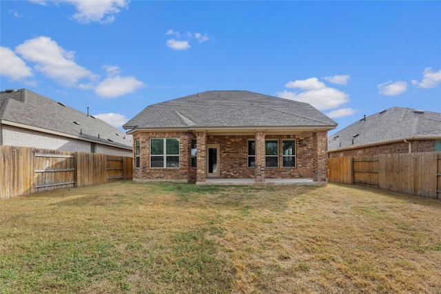 rear view of house featuring a patio area and a lawn