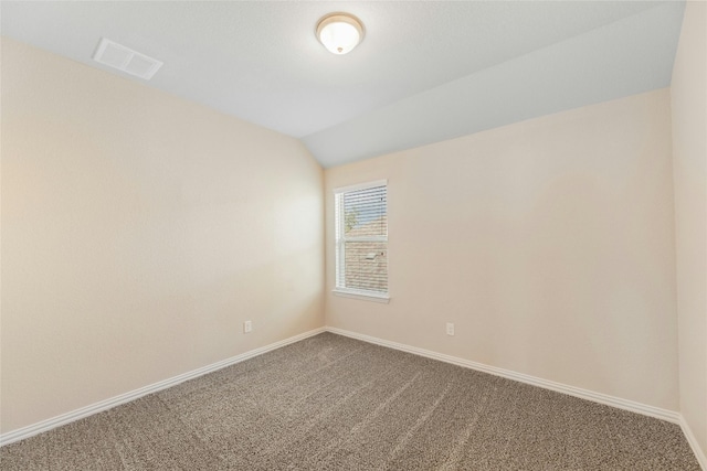 empty room featuring lofted ceiling and carpet flooring