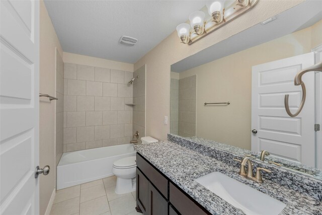 full bathroom featuring a textured ceiling, toilet, vanity, tiled shower / bath combo, and tile patterned flooring