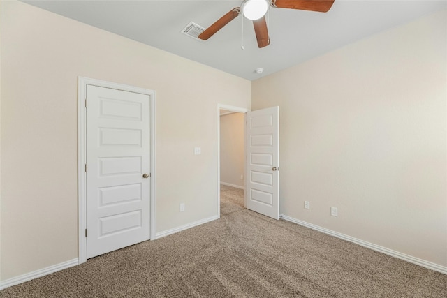 carpeted spare room featuring ceiling fan