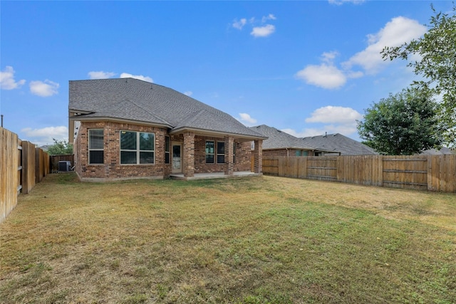 rear view of house with a yard and central AC unit