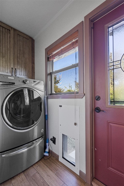 laundry room featuring a healthy amount of sunlight, cabinets, and washer / clothes dryer