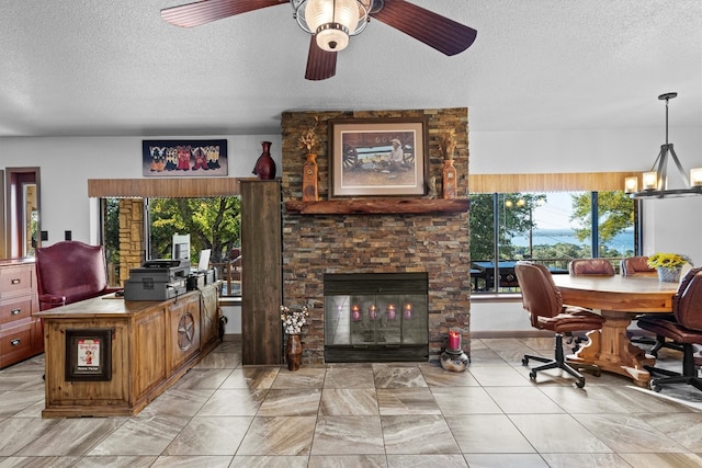 interior space featuring a fireplace, a textured ceiling, and ceiling fan with notable chandelier