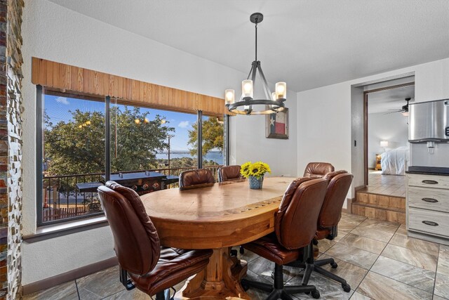 dining space with ceiling fan with notable chandelier