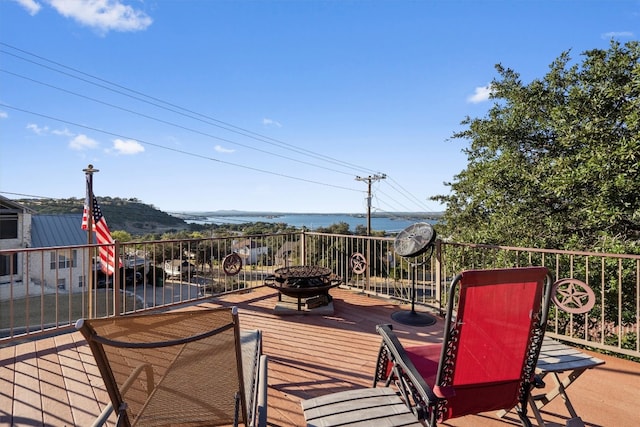 wooden deck featuring a water view and an outdoor fire pit