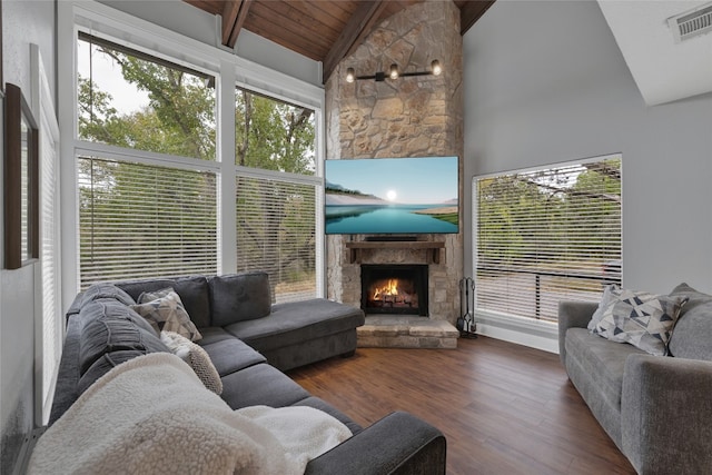 living room with dark hardwood / wood-style flooring, high vaulted ceiling, a stone fireplace, and beam ceiling