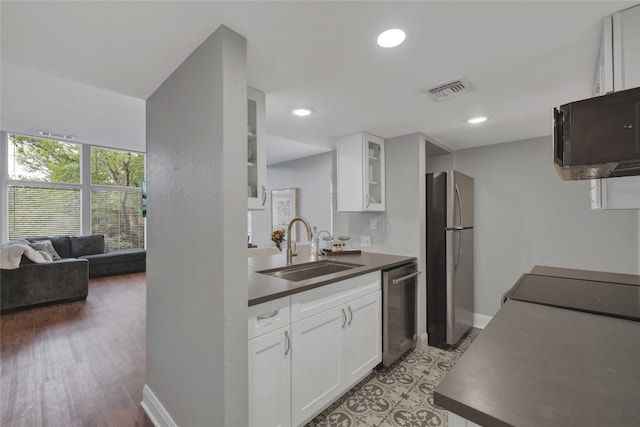 kitchen with white cabinetry, appliances with stainless steel finishes, sink, and hardwood / wood-style flooring