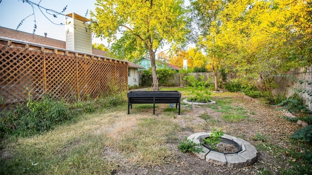 view of yard featuring a fire pit and a fenced backyard