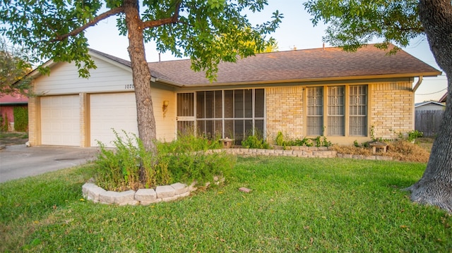 single story home with a front yard and a garage