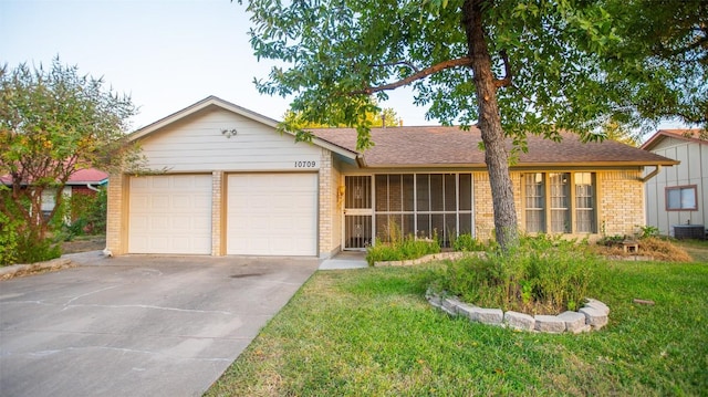single story home with brick siding, concrete driveway, a garage, a front yard, and a shingled roof