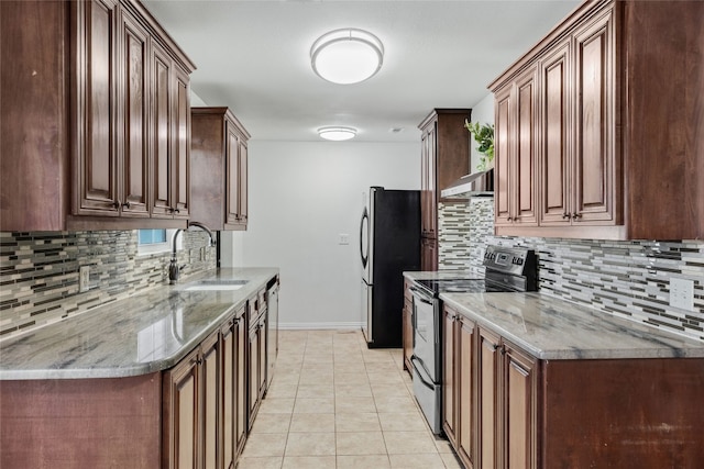 kitchen featuring backsplash, appliances with stainless steel finishes, light tile patterned floors, stone countertops, and sink