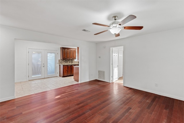 spare room featuring french doors, light wood-type flooring, and ceiling fan