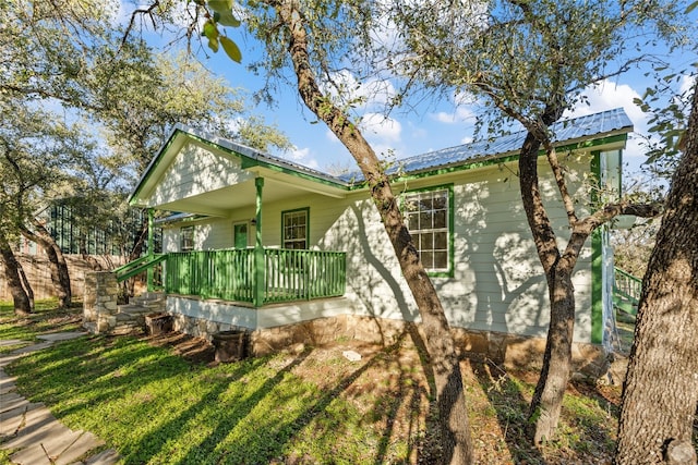 view of property exterior with a yard and a porch