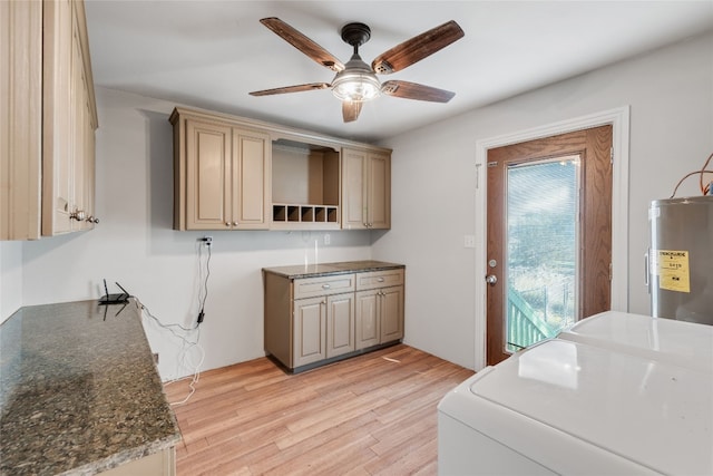 kitchen featuring ceiling fan, dark stone counters, light hardwood / wood-style flooring, water heater, and independent washer and dryer