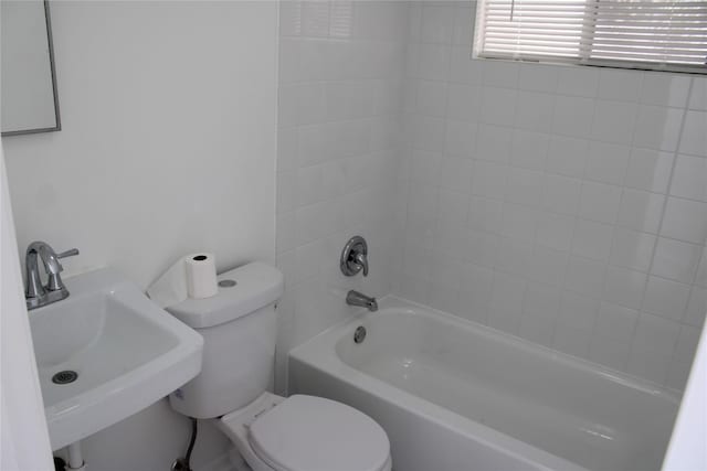 full bathroom with tiled shower / bath, sink, and toilet