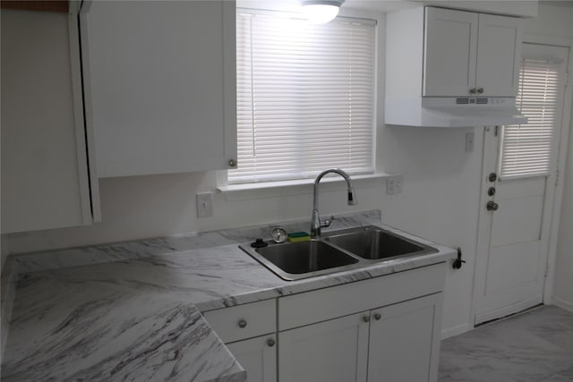 kitchen featuring a wealth of natural light, sink, white cabinetry, and light stone counters