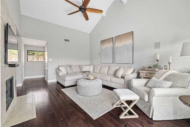 living room with ceiling fan, high vaulted ceiling, a fireplace, and dark hardwood / wood-style flooring