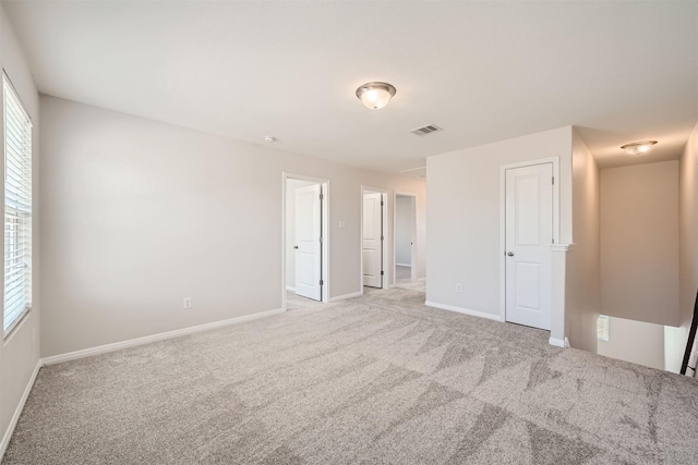 spare room featuring light colored carpet