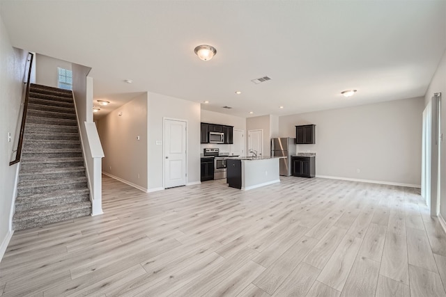 unfurnished living room featuring light hardwood / wood-style floors and sink