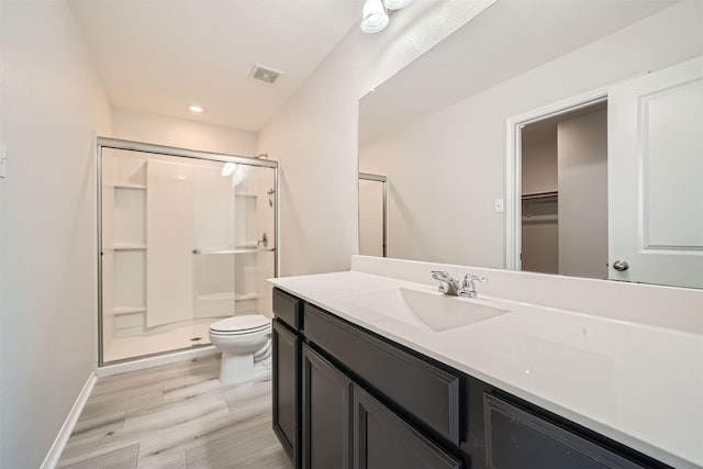 bathroom featuring walk in shower, vanity, toilet, and hardwood / wood-style floors