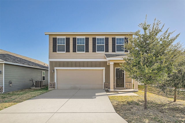 view of front of property with a garage and central AC