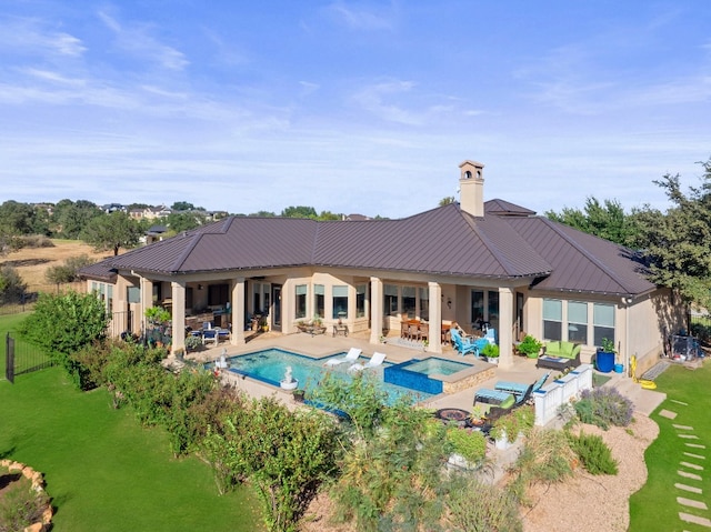 back of property with a patio area, a pool with hot tub, and a lawn