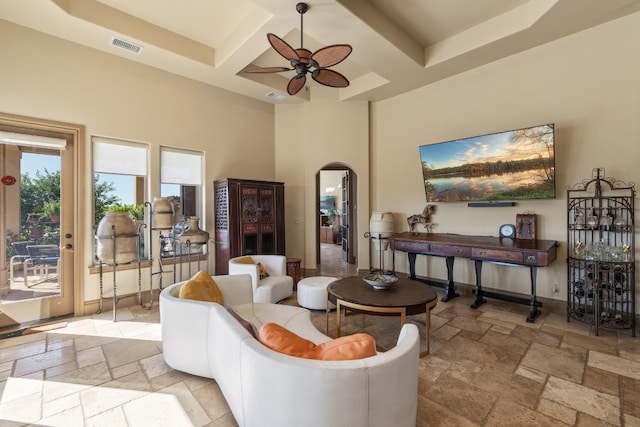 living room featuring beam ceiling, coffered ceiling, a high ceiling, and ceiling fan