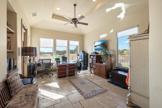 home office featuring ceiling fan and a raised ceiling