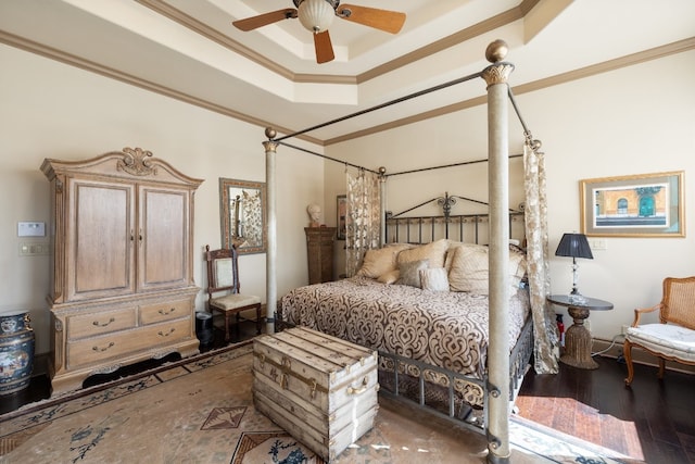 bedroom featuring ceiling fan, a tray ceiling, ornamental molding, and dark hardwood / wood-style flooring