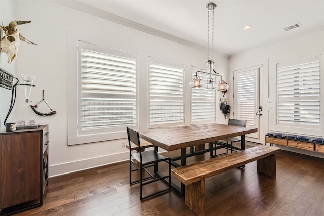 dining area with ornamental molding and dark hardwood / wood-style flooring