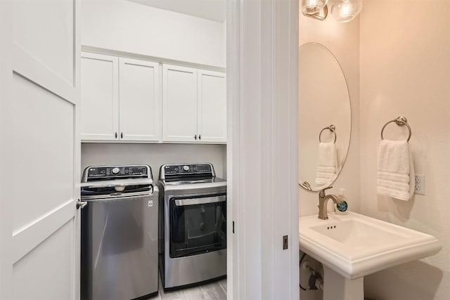 1100 Railroad Ave, Georgetown, TX 78626 - clothes washing area with cabinet space, washing machine and dryer, and a sink