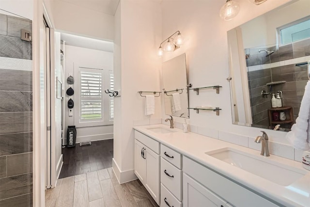 1100 Railroad Ave, Georgetown, TX 78626 - full bath with double vanity, tiled shower, a sink, and wood finished floors
