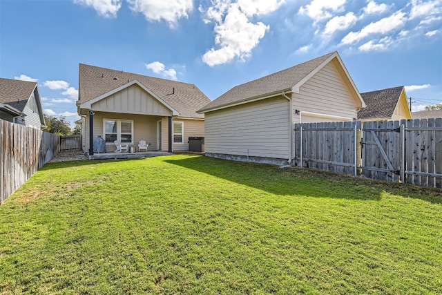 back of house featuring a patio area and a lawn