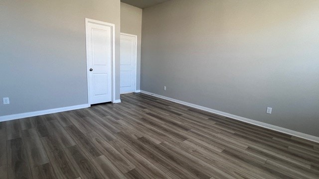 unfurnished bedroom with dark hardwood / wood-style flooring