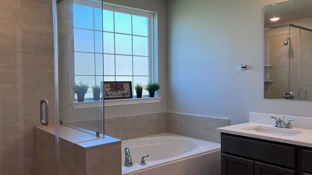 bathroom featuring vanity and independent shower and bath