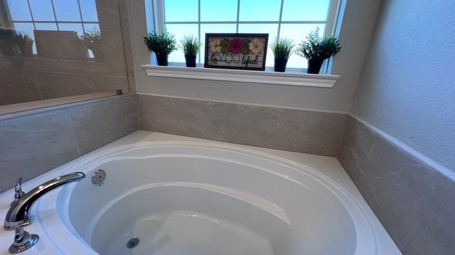 bathroom with a wealth of natural light and a bath