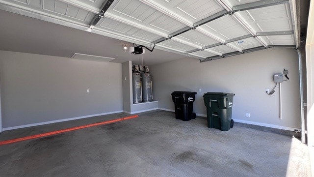 garage featuring gas water heater, a garage door opener, and water heater