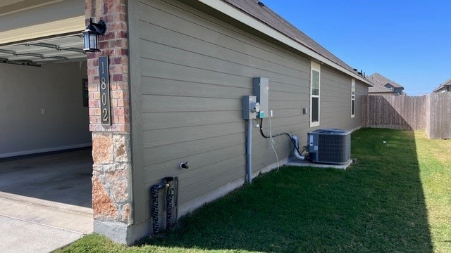 view of home's exterior featuring a yard and central AC unit