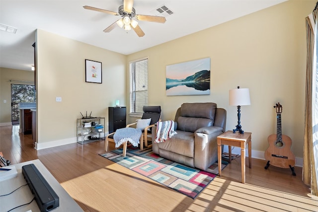 living room with ceiling fan and dark hardwood / wood-style flooring