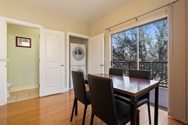 dining space featuring stacked washer / dryer and light hardwood / wood-style floors