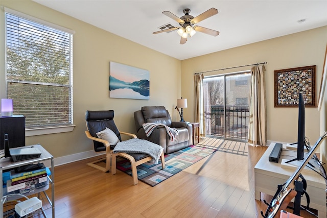 living area with light hardwood / wood-style flooring, a healthy amount of sunlight, and ceiling fan