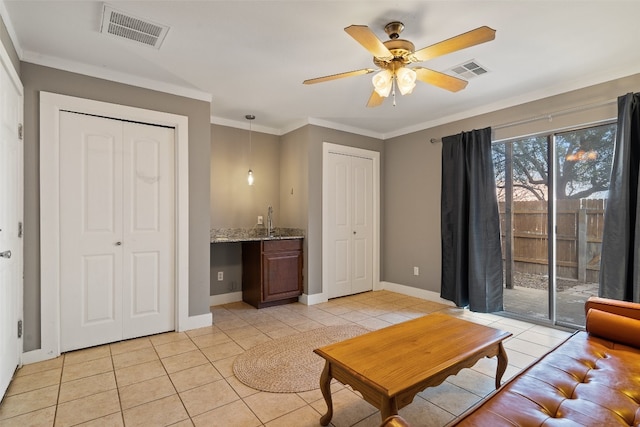 tiled living room with ceiling fan, crown molding, and sink