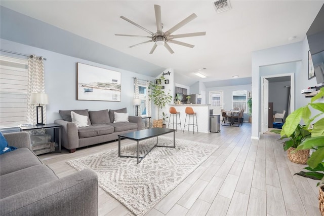 living room featuring light hardwood / wood-style flooring and ceiling fan