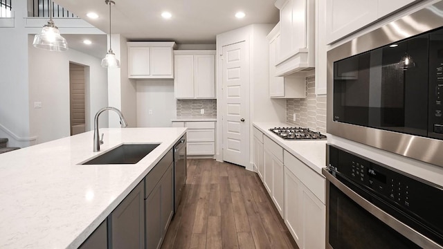 kitchen featuring dark wood finished floors, stainless steel appliances, recessed lighting, white cabinetry, and a sink